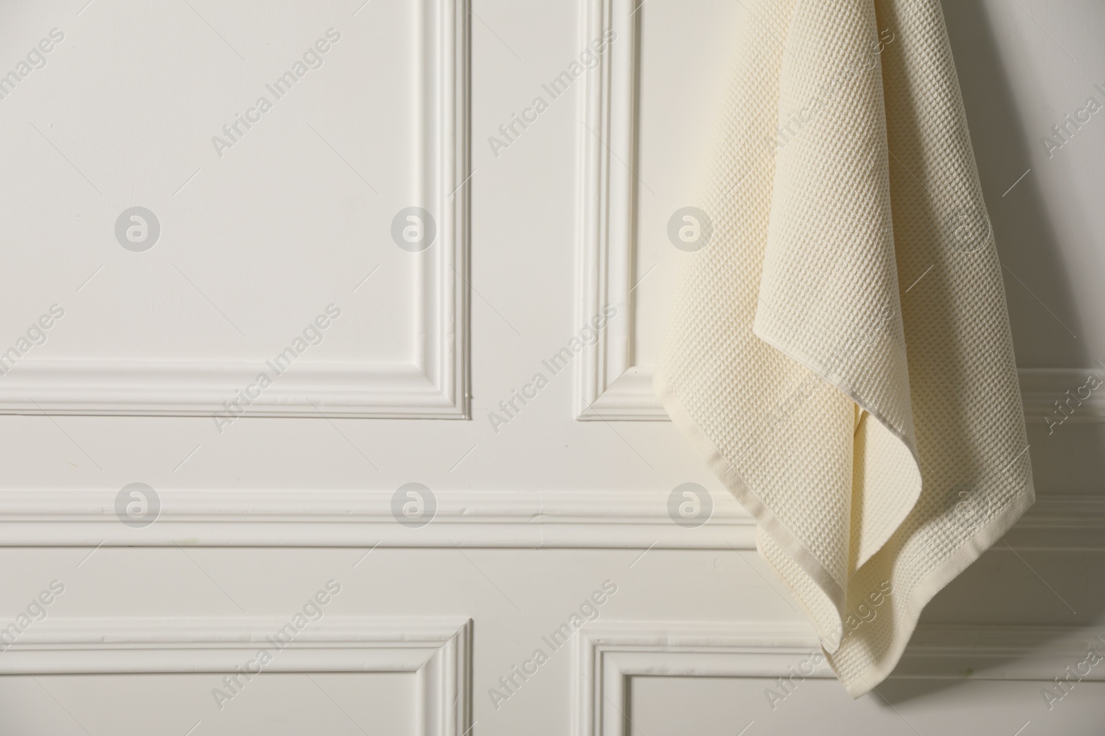 Clean waffle towel hanging on white wall, closeup. Space for text Photo of Clean waffle towel hanging on white wall, closeup. Space for text