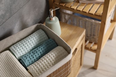Photo of Clean waffle towels on wooden dresser in bathroom, closeup