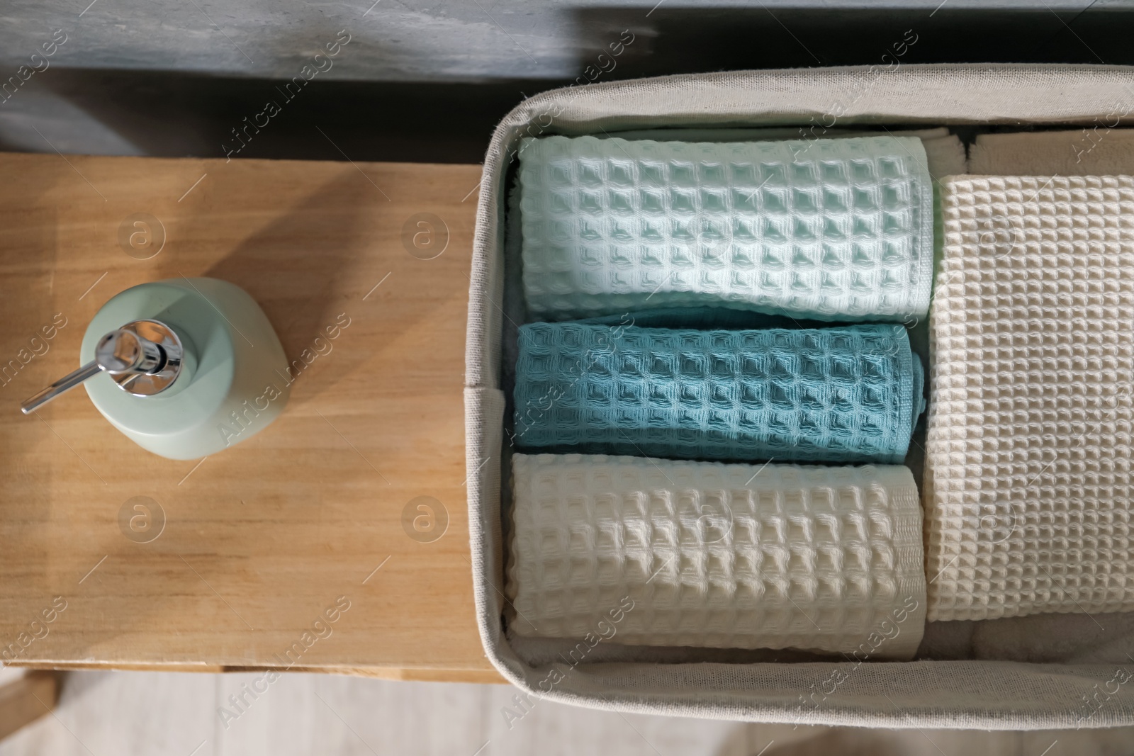 Clean waffle towels and reed diffuser on wooden dresser in bathroom, flat lay Photo of Clean waffle towels and reed diffuser on wooden dresser in bathroom, flat lay