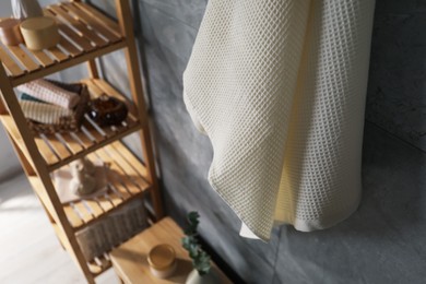 Photo of Clean waffle towel and other bath products near grey wall in bathroom, above view