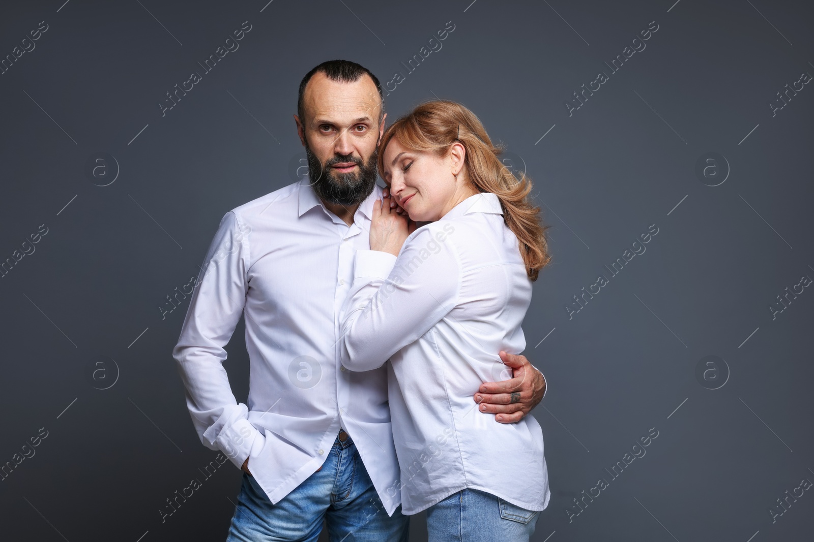 Photo of Portrait of lovely couple on grey background
