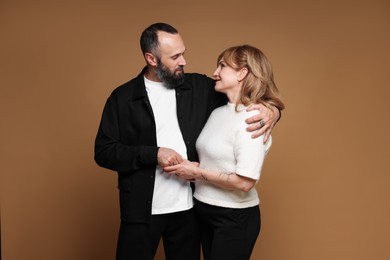 Photo of Portrait of lovely couple on brown background