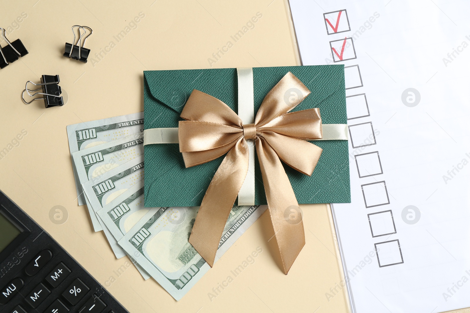 Money bonus. Envelope, dollar banknotes, binder clips, calculator and checklist on beige background, flat lay Photo of Money bonus. Envelope, dollar banknotes, binder clips, calculator and checklist on beige background, flat lay