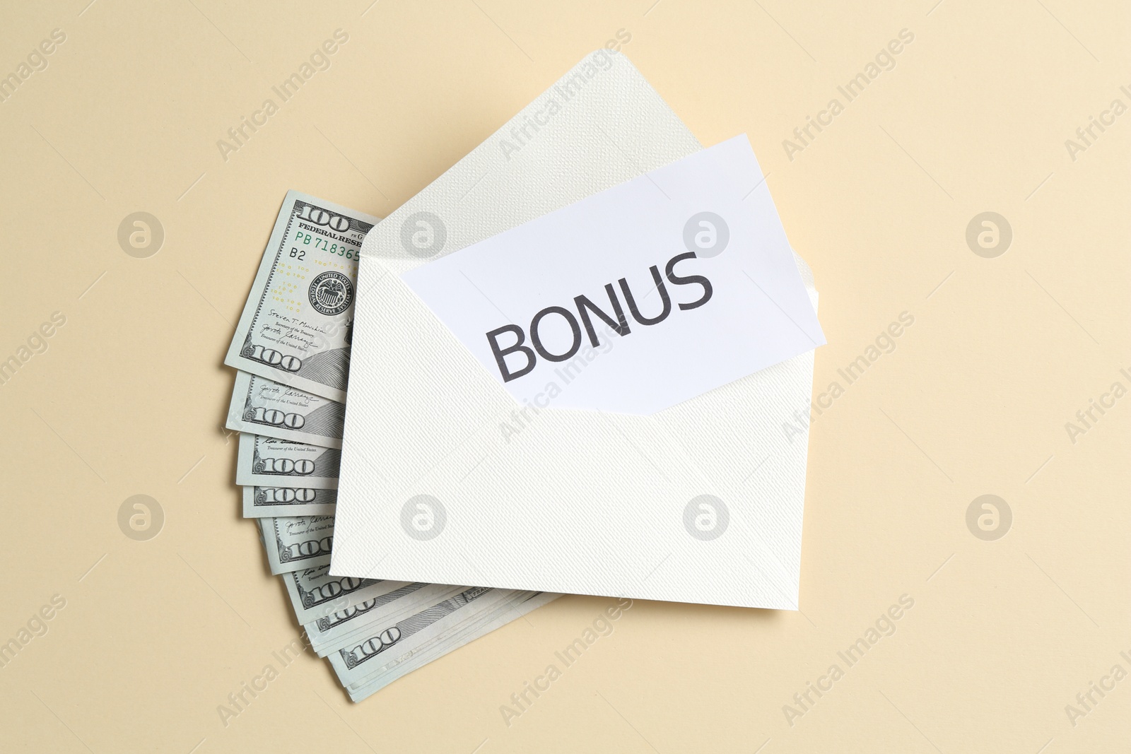 Card with word Bonus, envelope and dollar banknotes on beige background, flat lay Photo of Card with word Bonus, envelope and dollar banknotes on beige background, flat lay