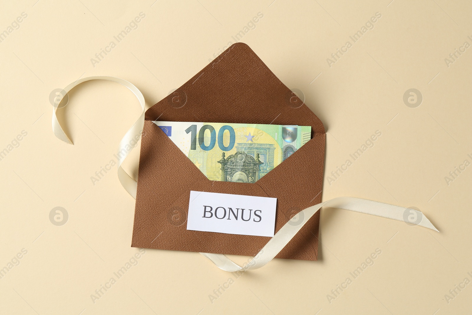 Money bonus. Envelope with euro banknote and ribbon on beige background, top view Photo of Money bonus. Envelope with euro banknote and ribbon on beige background, top view