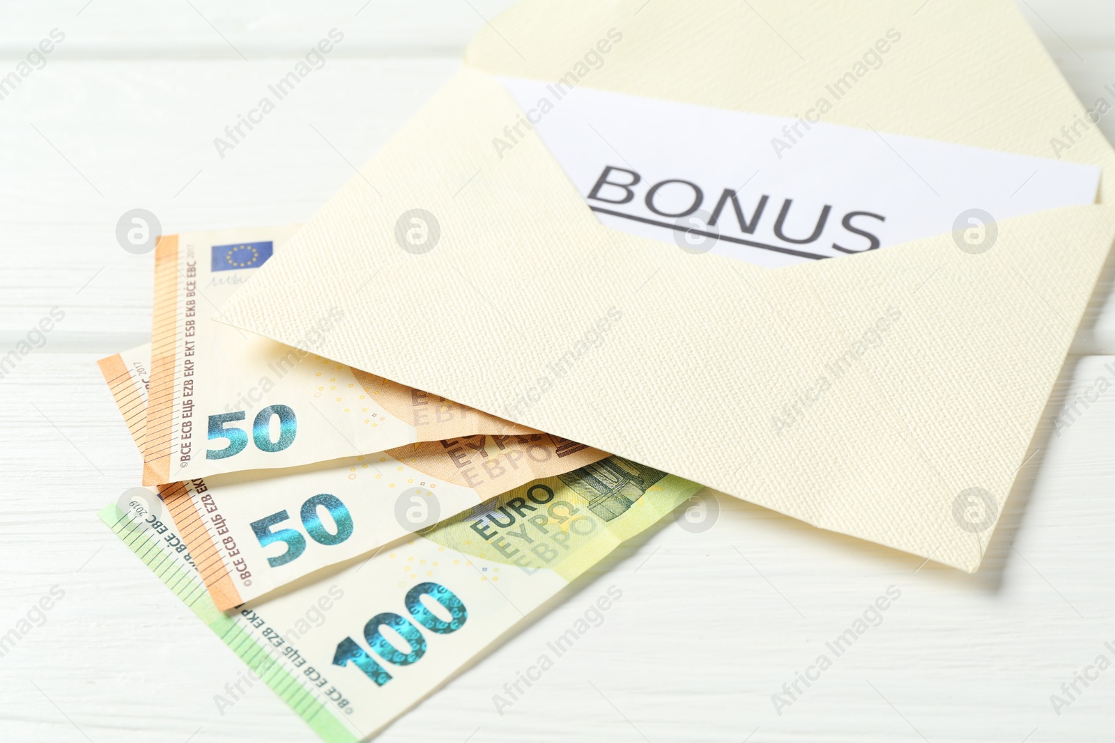 Envelope, card with word Bonus and euro banknotes on white wooden table, closeup Photo of Envelope, card with word Bonus and euro banknotes on white wooden table, closeup