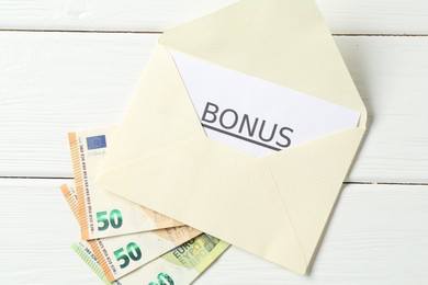 Photo of Envelope, card with word Bonus and euro banknotes on white wooden table, flat lay