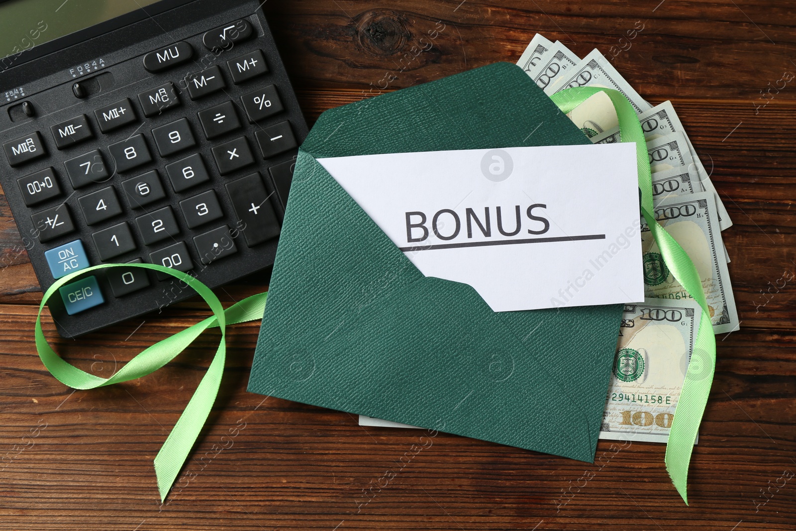 Card with word Bonus, envelope, dollar banknotes, calculator and ribbon on wooden table, flat lay Photo of Card with word Bonus, envelope, dollar banknotes, calculator and ribbon on wooden table, flat lay