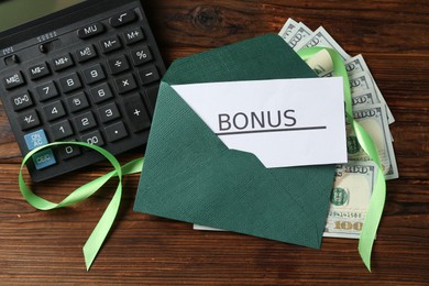 Photo of Card with word Bonus, envelope, dollar banknotes, calculator and ribbon on wooden table, flat lay