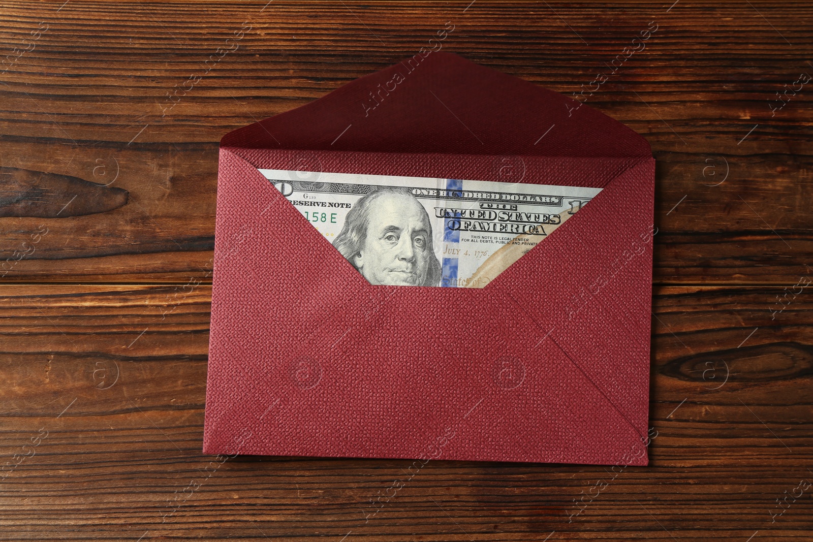 Money bonus. Envelope with dollar banknote on wooden table, top view Photo of Money bonus. Envelope with dollar banknote on wooden table, top view