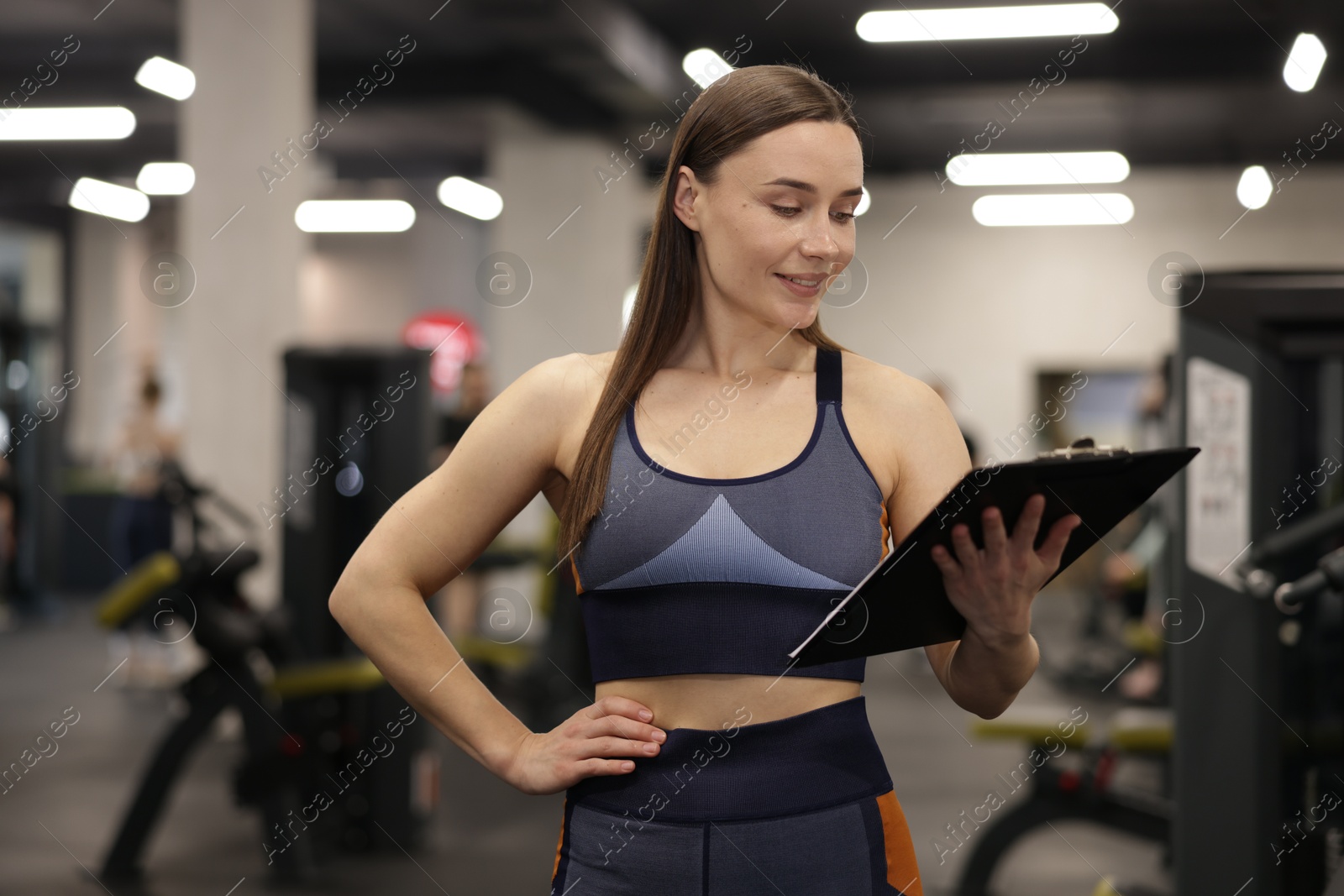 Photo of Professional personal trainer with clipboard in gym