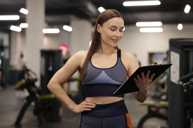 Photo of Professional personal trainer with clipboard in gym