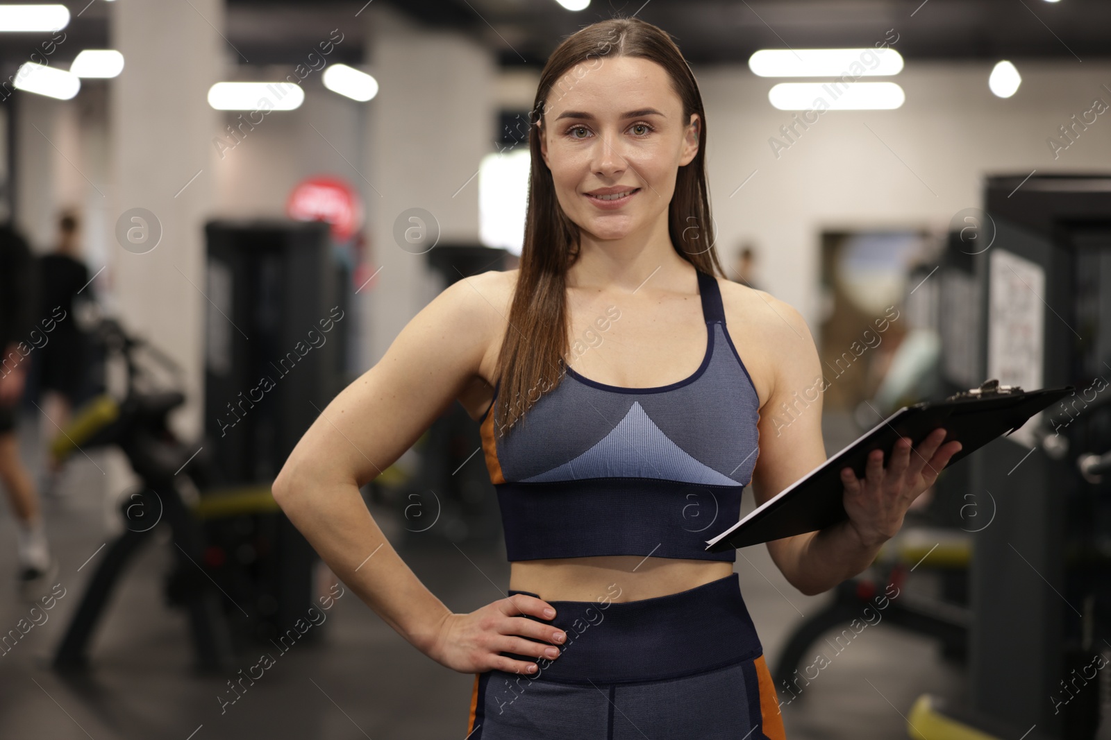 Professional personal trainer with clipboard in gym Photo of Professional personal trainer with clipboard in gym