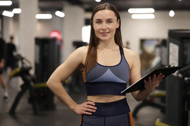 Photo of Professional personal trainer with clipboard in gym
