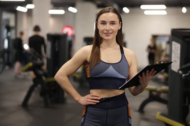 Photo of Professional personal trainer with clipboard in gym