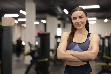 Photo of Portrait of professional personal trainer in gym. Space for text