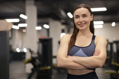 Photo of Portrait of professional personal trainer in gym. Space for text