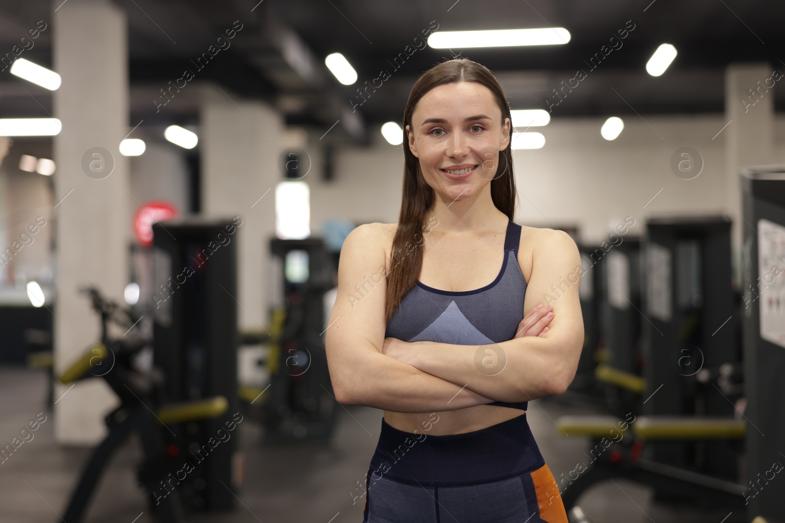 Photo of Portrait of professional personal trainer in gym. Space for text