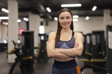 Photo of Portrait of professional personal trainer in gym. Space for text