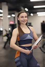 Photo of Professional personal trainer with clipboard in gym