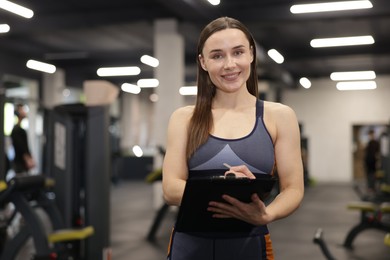 Photo of Professional personal trainer with clipboard in gym
