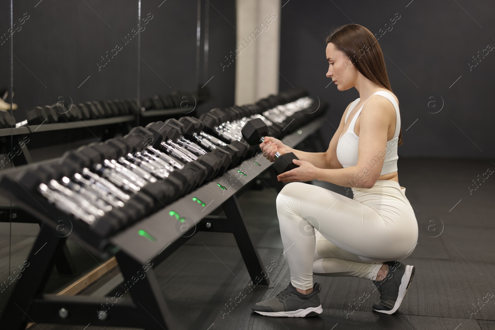 Photo of Personal trainer with dumbbells in sport center