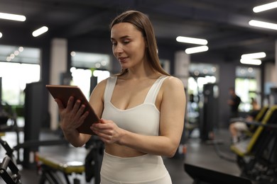 Photo of Personal trainer with tablet in sport center