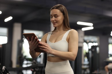 Photo of Personal trainer with tablet in sport center