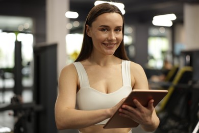 Photo of Personal trainer with tablet in sport center