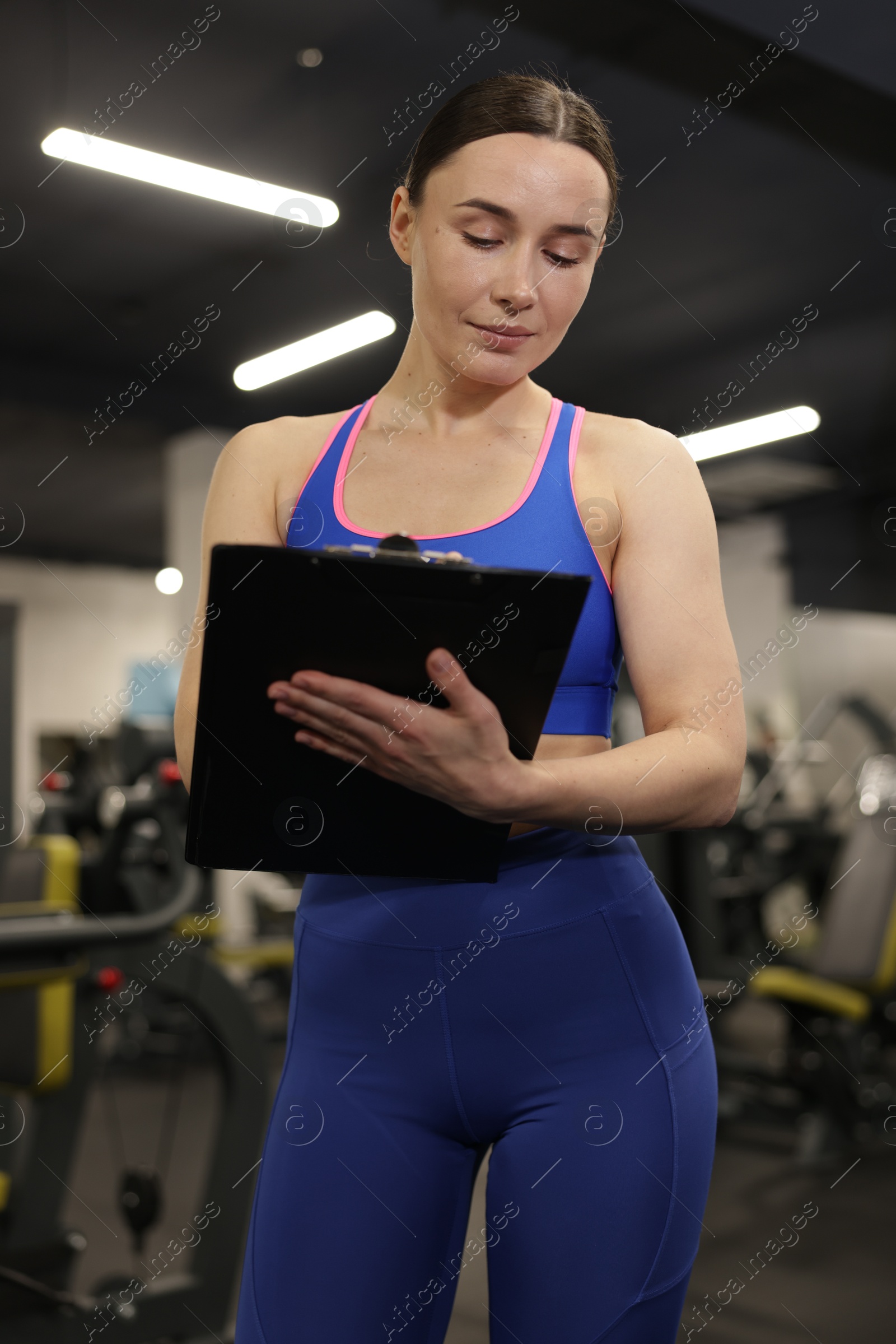 Photo of Professional personal trainer with clipboard in gym