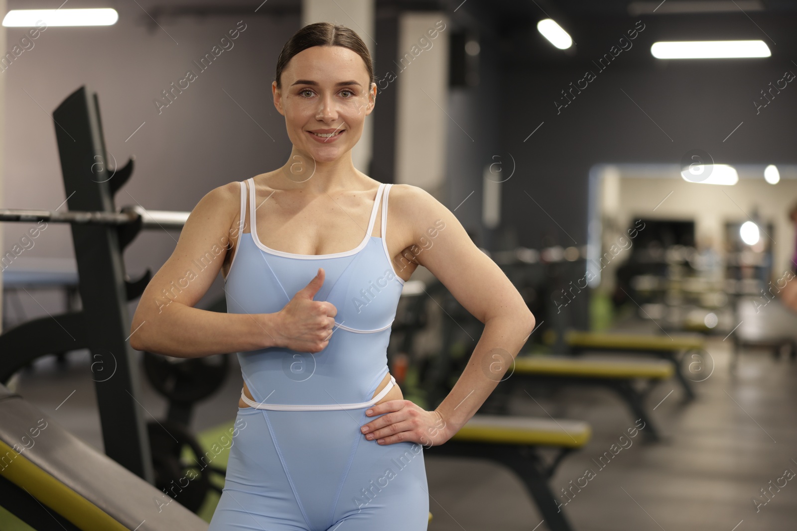 Photo of Professional trainer showing thumbs up in gym