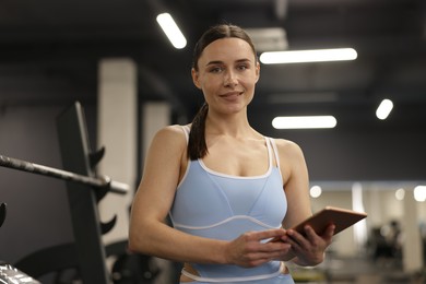 Photo of Professional personal trainer with tablet in gym
