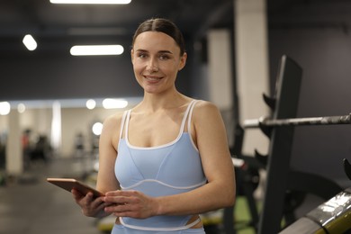 Photo of Professional personal trainer with tablet in gym