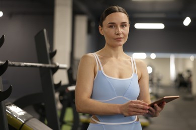 Photo of Professional personal trainer with tablet in gym