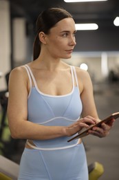 Photo of Professional personal trainer with tablet in gym