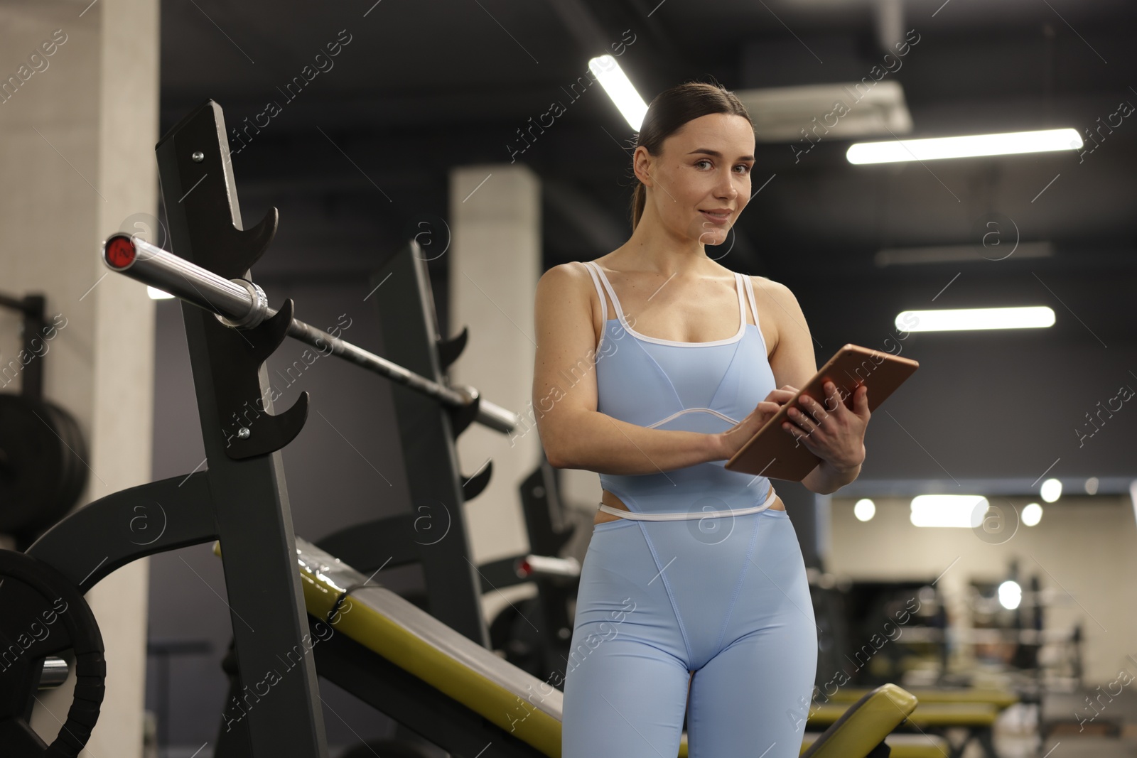 Photo of Professional personal trainer with tablet in gym
