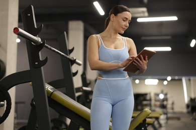 Photo of Professional personal trainer with tablet in gym