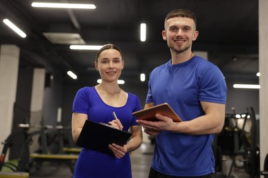 Photo of Personal trainers with clipboard and tablet in gym
