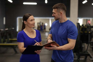 Photo of Personal trainers with clipboard and tablet in gym