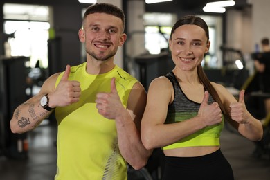 Photo of Personal trainers showing thumbs ups in gym