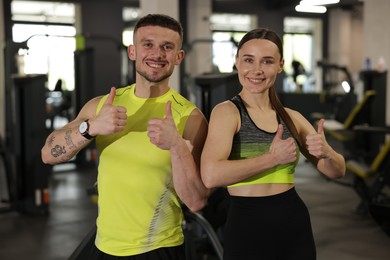 Photo of Personal trainers showing thumbs ups in gym