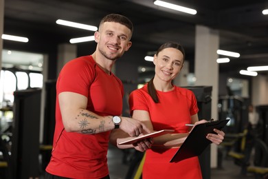Photo of Personal trainers with tablet and clipboard in gym