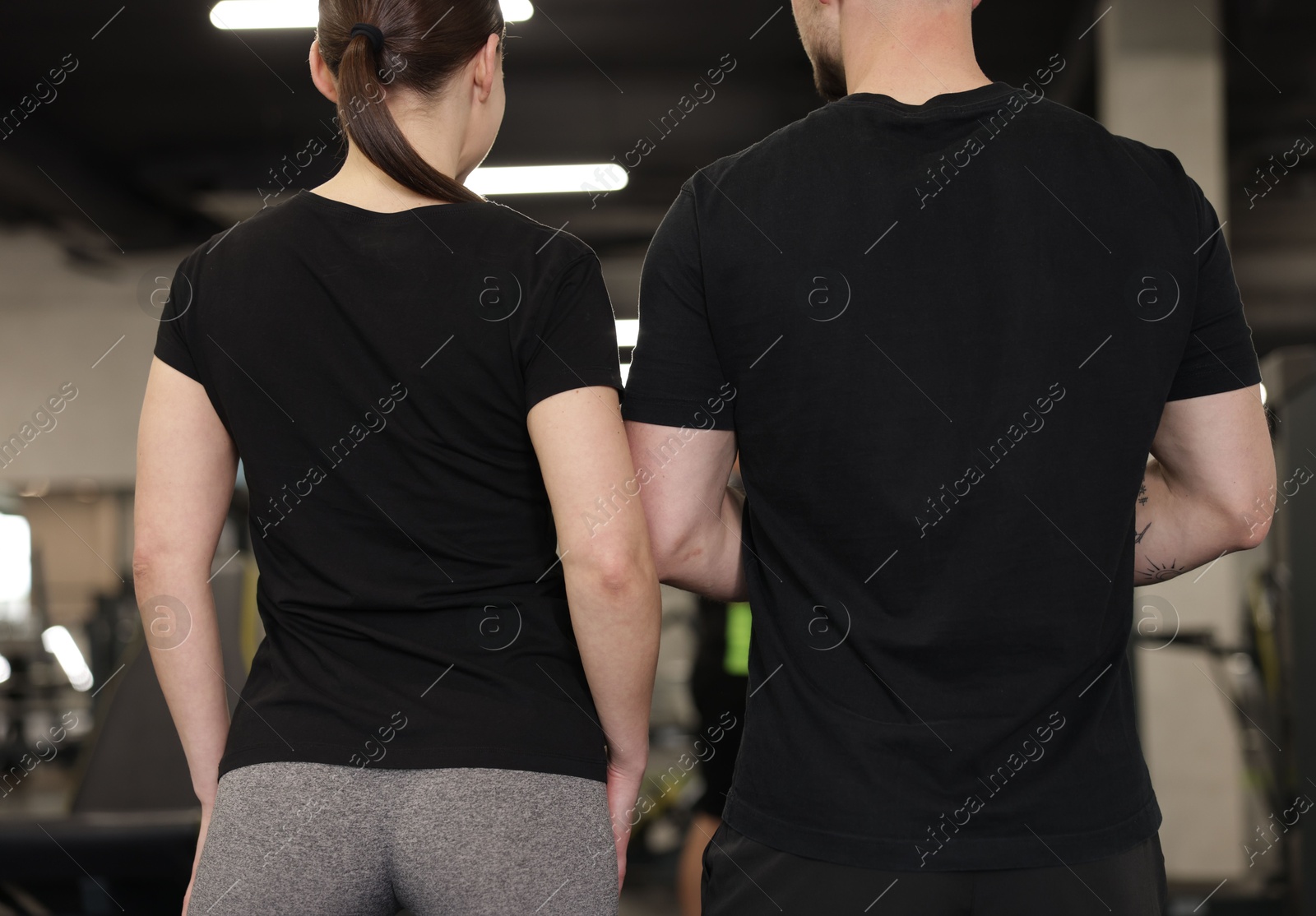 Photo of Personal trainers in sport center, back view