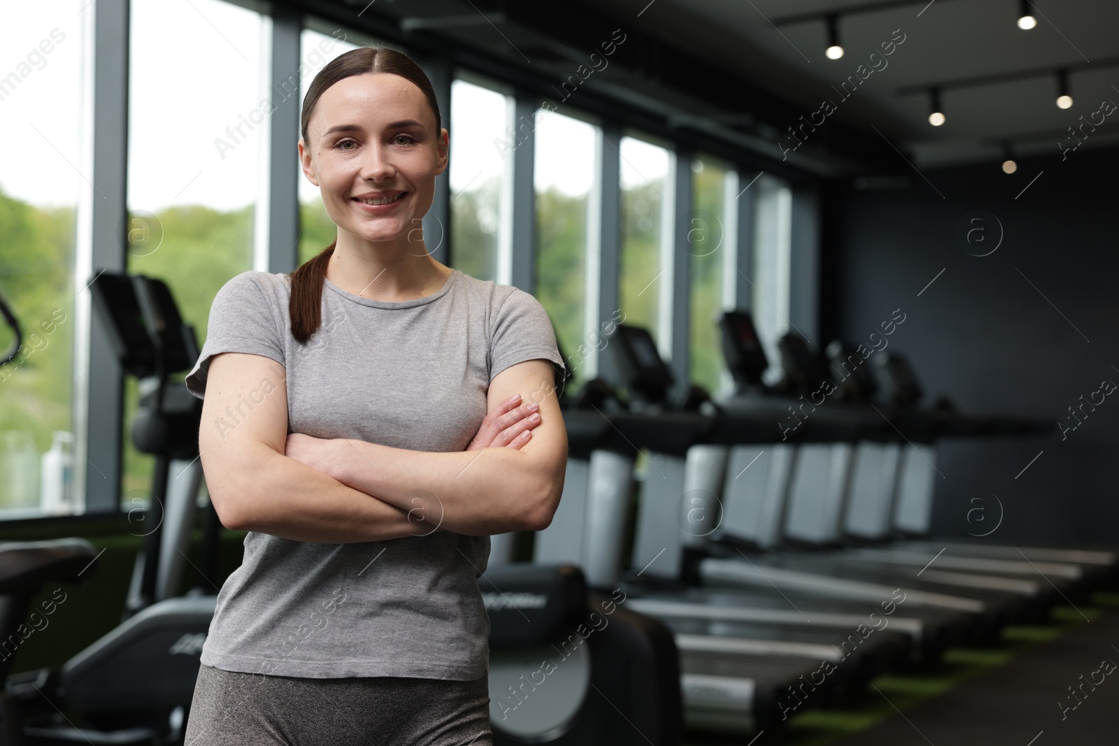 Photo of Portrait of personal trainer in sport center. Space for text