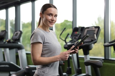 Photo of Professional personal trainer with clipboard in gym