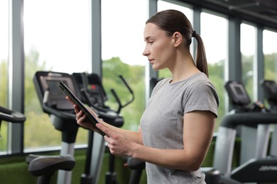 Photo of Professional personal trainer with clipboard in gym