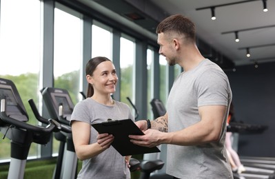 Photo of Professional personal trainers with clipboard in gym
