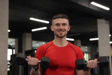 Photo of Professional personal trainer with dumbbells in gym