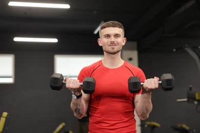 Photo of Professional personal trainer with dumbbells in gym