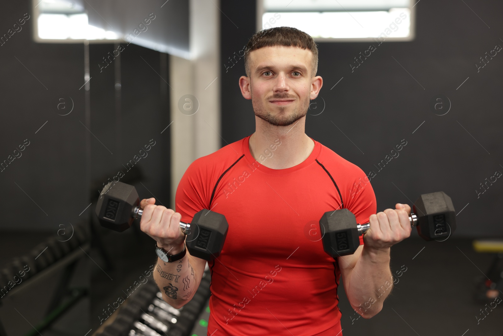 Professional personal trainer with dumbbells in gym Photo of Professional personal trainer with dumbbells in gym